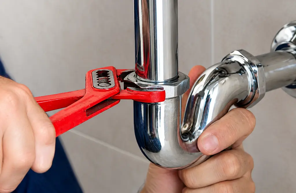 Plumber repairing chrome sink pipes